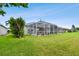 Large backyard with grassy lawn and screened-in pool area at 5056 Lakehurst Ct, Palmetto, FL 34221