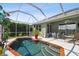 Inviting screened-in pool with brick coping and backyard view at 5056 Lakehurst Ct, Palmetto, FL 34221
