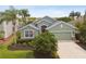 One-story green house with red door and landscaping at 5056 Lakehurst Ct, Palmetto, FL 34221