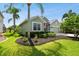 Well-maintained house with a landscaped lawn, and palm trees at 5056 Lakehurst Ct, Palmetto, FL 34221