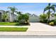 House exterior, green two-car garage, manicured lawn, palm trees at 5056 Lakehurst Ct, Palmetto, FL 34221
