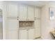 Well-designed kitchen with ample storage in off-white cabinets at 391 Aruba Cir # 302, Bradenton, FL 34209