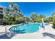 Community pool with lounge chairs and umbrellas at 391 Aruba Cir # 302, Bradenton, FL 34209