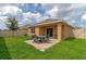 Backyard view showcasing patio with seating area and grassy lawn at 5852 Elegant Orchid Way, Sarasota, FL 34232