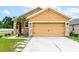 Tan house with a two-car garage and landscaping at 5852 Elegant Orchid Way, Sarasota, FL 34232