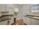 Kitchen features white cabinets, dark counters, and tile floors at 1677 4Th St, Sarasota, FL 34236