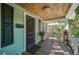 Front porch with wooden flooring, white railings, and a screen door at 1677 4Th St, Sarasota, FL 34236