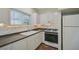 Kitchen with white cabinets, dark countertops, and tile floors at 1677 4Th St, Sarasota, FL 34236