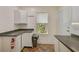L-shaped kitchen with white cabinets and dark counters at 1677 4Th St, Sarasota, FL 34236