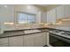 White kitchen with dark countertops and tile floor at 1677 4Th St, Sarasota, FL 34236