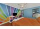 Bright bedroom with colorful wall art, hardwood floors, and a comfy bed at 3917 Cochise Ter, Sarasota, FL 34233