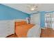 Bedroom with white dresser, orange bedding, and access to hallway at 3917 Cochise Ter, Sarasota, FL 34233
