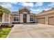 Front view of a house with a three car garage and stone facade at 22408 76Th E Ave, Bradenton, FL 34211