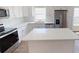Bright kitchen boasts white cabinets, a large island, and stainless steel appliances at 710 N Thomas St, Plant City, FL 33563
