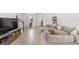 Bright living room with large sectional sofa and hardwood floors. View of staircase and entryway at 4119 Via Sienna Cir, Sarasota, FL 34243