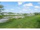 View of pond and community, green grass, and homes at 4119 Via Sienna Cir, Sarasota, FL 34243