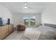 Main bedroom with large windows, plush bed, dresser, and desk at 4119 Via Sienna Cir, Sarasota, FL 34243