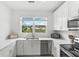 Modern kitchen with white cabinets, stainless steel appliances and a view of the backyard at 4119 Via Sienna Cir, Sarasota, FL 34243