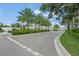 Attractive community entrance with lush landscaping and palm trees at 4119 Via Sienna Cir, Sarasota, FL 34243