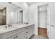 This bathroom includes double sinks, a large mirror, and access to the walk-in closet and shower at 18812 Dayspring Pl, Venice, FL 34293