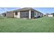 Backyard view showcasing the screened lanai and well-maintained lawn at 18824 Dayspring Pl, Venice, FL 34293