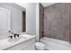 Bathroom featuring white cabinets, quartz countertop, and tiled shower at 18824 Dayspring Pl, Venice, FL 34293