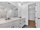 Bathroom featuring double vanities and an open doorway to the walk-in closet at 18824 Dayspring Pl, Venice, FL 34293
