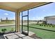 View from the screened lanai, complete with stone floor, shows manicured yard at 18824 Dayspring Pl, Venice, FL 34293