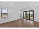 Sunlit living room featuring large windows, hardwood floors, and sliding glass doors at 18824 Dayspring Pl, Venice, FL 34293