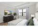 Relaxing bedroom with tray ceiling, dresser with TV and outside view at 18824 Dayspring Pl, Venice, FL 34293
