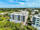 Aerial view of a condo building with balconies, surrounded by lush greenery and other community buildings at 236 Hidden Bay Dr # 301, Osprey, FL 34229