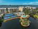 Stunning aerial view of the community with buildings, tennis courts, a pool, and a waterfront location at 236 Hidden Bay Dr # 301, Osprey, FL 34229