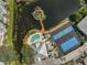 Aerial view of community amenities, including a tennis court, pool, and pond with island at 236 Hidden Bay Dr # 301, Osprey, FL 34229
