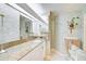 Well-lit bathroom featuring vanity, textured wallpaper, glass blocks, and decorative accents at 236 Hidden Bay Dr # 301, Osprey, FL 34229