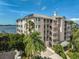 Stunning exterior view of a multi-level condo building near Sarasota Bay with lush, mature landscaping at 236 Hidden Bay Dr # 301, Osprey, FL 34229
