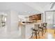 Open kitchen with granite countertops, wooden cabinets, island with seating, and views into the dining area at 236 Hidden Bay Dr # 301, Osprey, FL 34229