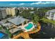 Aerial view of a community pool and spa with palm trees and a surrounding wooden deck on the water at 236 Hidden Bay Dr # 301, Osprey, FL 34229