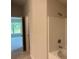 Bathroom featuring tiled shower and access to bright bedroom with a large window at 5661 Gaffney Rd, North Port, FL 34286