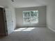 Sunlit bedroom with neutral carpet, white trim, and a view to the outside at 5661 Gaffney Rd, North Port, FL 34286