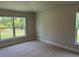 Bright bedroom with neutral carpeting, ample natural light, and two windows showing a view at 5661 Gaffney Rd, North Port, FL 34286