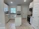 Bright kitchen featuring white cabinets, granite countertops, stainless steel appliances, and wood-look tile flooring at 5661 Gaffney Rd, North Port, FL 34286