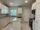 Modern kitchen with white cabinets, granite countertops, and stainless steel appliances at 5661 Gaffney Rd, North Port, FL 34286