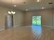 Bright and airy living room featuring sliding glass doors and wood-look tile flooring at 5661 Gaffney Rd, North Port, FL 34286
