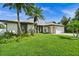 Single-story home with a two-car garage and lush landscaping at 10194 Thames Ave, Englewood, FL 34224