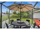Relaxing screened patio with table, chairs, and umbrella, perfect for outdoor dining at 10194 Thames Ave, Englewood, FL 34224