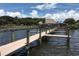 A wooden dock leads to a waterfront bar with thatched roof at 236 Hidden Bay Dr # 301, Osprey, FL 34229