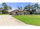 Home with a driveway and lush green grass at 11358 Lomita Wren Rd, Weeki Wachee, FL 34614