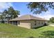 Tan house exterior, screened patio, and a large backyard at 11358 Lomita Wren Rd, Weeki Wachee, FL 34614