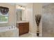 Bathroom with single vanity, soaking tub and shower at 11358 Lomita Wren Rd, Weeki Wachee, FL 34614