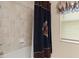Bathroom features a tub, shower, and patterned shower curtain at 11358 Lomita Wren Rd, Weeki Wachee, FL 34614